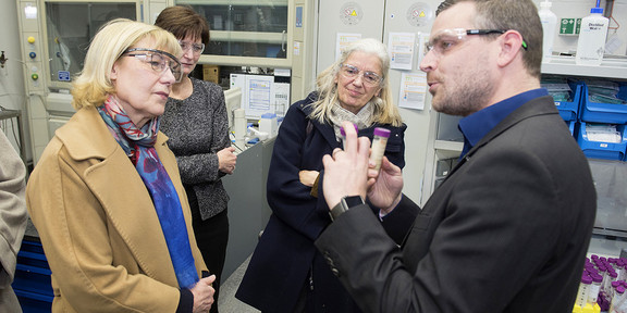 Drei Frauen und ein Mann im Gespräch miteinander in einem Labor