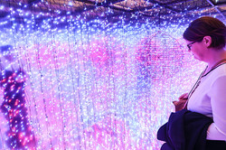 Besucherin steht vor einer lilafarbenden Installation bei der Ausstellung „Engineering meets Art“