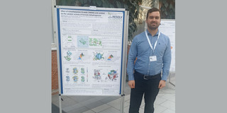 Mr. Erviti stands next to his poster showing the results of his research.