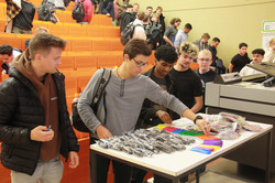 Erstsemester nehmen Werbegeschenke vom Auslagentisch