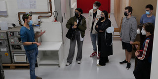 Gruppe interessierter Personen wird eine Versuchsanlage erklärt