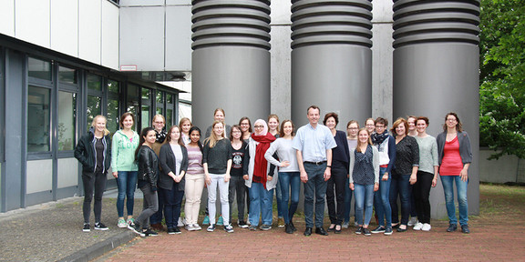 Eine Gruppe von Frauen steht in zwei Reihen nebeneinander vor dem Gebäude der BCI