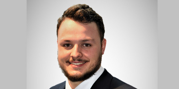 Portraitfoto von Michael-David Fischer. Er trägt einen Anzug mit farbiger Krawatte, hat dunkles, kurzes Haar und ist geschätzt Mitte 20.