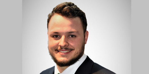 Portraitfoto von Michael-David Fischer. Er trägt einen Anzug mit farbiger Krawatte, hat dunkles, kurzes Haar und ist geschätzt Mitte 20.