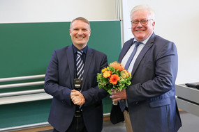 Dekan überreicht Blumenstraß an den ehemaligen Leiter des Lehstules TC Herrn Dr. Agar