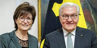 Frau Prof. Gabriele Sadowski und der deutsche Bundespräsident Frank-Walter Steinmeier stehen nebeneinander und lächeln in die Kamera. Beide tragen Brillen und sind formell gekleidet. 