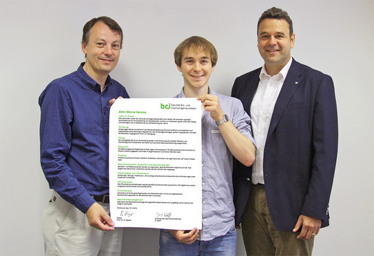 Dominik Wolff hält die neue 10-Sterne-Vereinbarung hoch. Prof. Kayser und Prof. Kockmann stehen rechts und links von ihm.