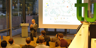 Jubilee Lecture mit Prof. Philippe A. Tanguy Redner steht vor Publikum, im Hintergrund eine Beamerwand mit Präsentation