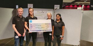  The 4 winners hold an oversized check with a value of 1000€.