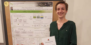 Frau Seifert steht, Ihre Urkunde haltend, vor Ihrem Poster.