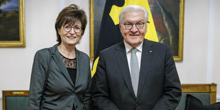 Frau Prof. Gabriele Sadowski und der deutsche Bundespräsident Frank-Walter Steinmeier stehen nebeneinander und lächeln in die Kamera. Beide tragen Brillen und sind formell gekleidet. 