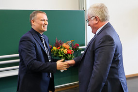 Dekan überreicht Blumenstraß an den ehemaligen Leiter des Lehstules TC Herrn Dr. Agar