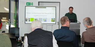 Vortrag beim Treffen des Alumnivereins fabcing der BCI, Sprecher an POdium neben Präsentation