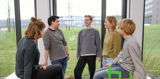 Ein Gruppenfoto von Studierenden im Seminarraum mit dem TU Dortmund Logo.